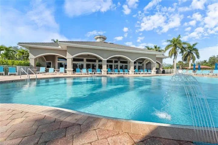 Community pool with a patio and fence