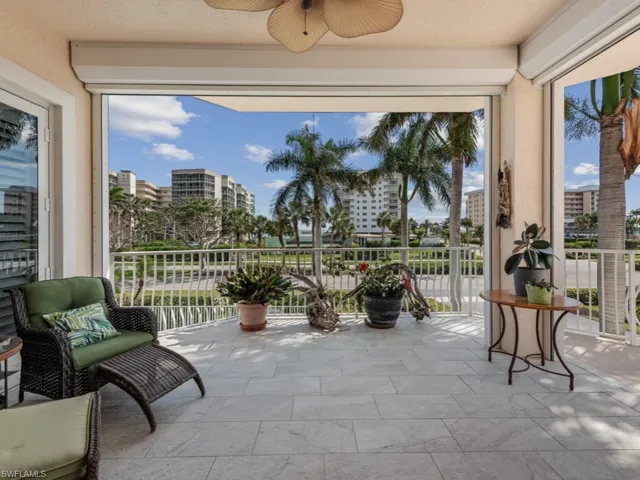 Sunroom with ceiling fan, a healthy amount of sunlight, and a city view