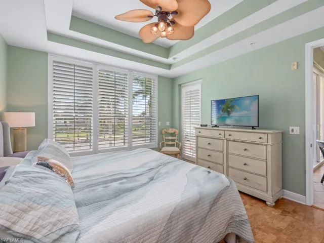 Bedroom with baseboards, a ceiling fan, and a raised ceiling