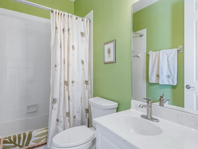 Full bath featuring shower / bath combination with curtain, toilet, and vanity