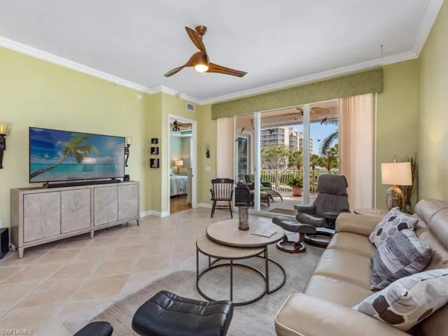 Living area with visible vents, baseboards, ornamental molding, ceiling fan, and light tile patterned floors
