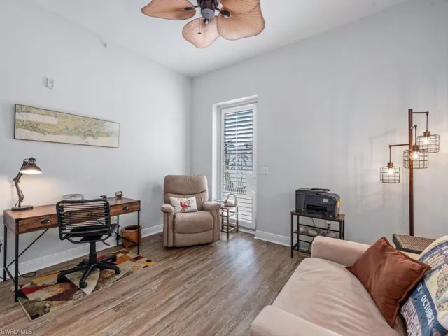 Office area with baseboards, wood finished floors, and a ceiling fan