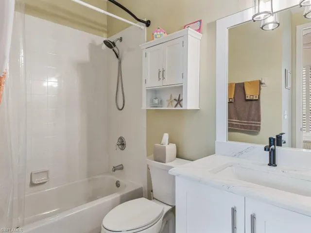 Bathroom with toilet, shower / bath combo, and vanity