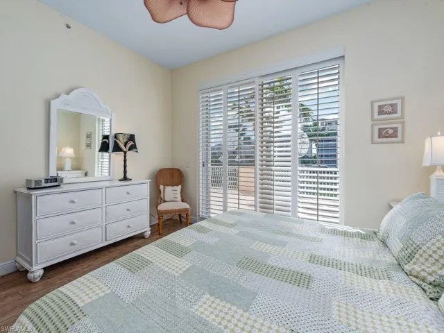 Bedroom featuring a ceiling fan, access to exterior, and dark wood finished floors