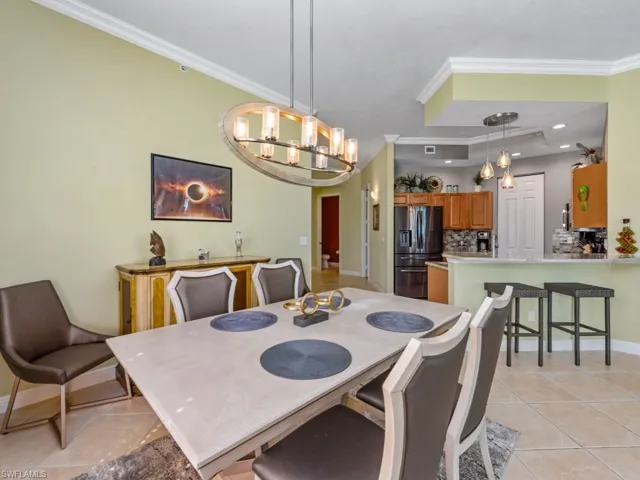 Dining space with crown molding, recessed lighting, baseboards, a chandelier, and light tile patterned flooring