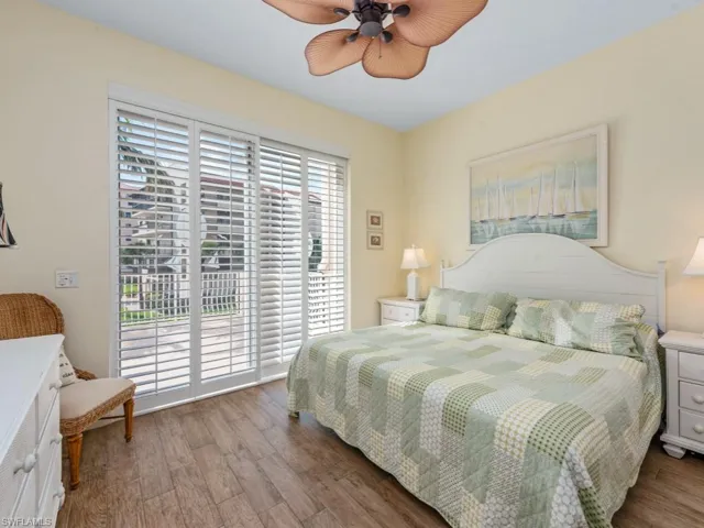 Bedroom with access to outside, wood finished floors, and a ceiling fan