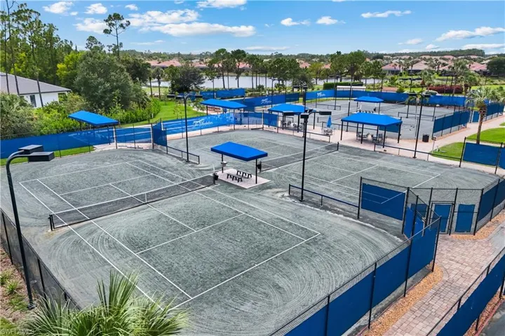 PICKLEBALL courts, shaded seating areas, overhead lighting.