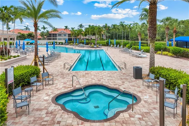 Multi-level swimming pool area featuring a spa, a lap pool, and a recreational pool, all surrounded by paver decking and extensive tropical landscaping