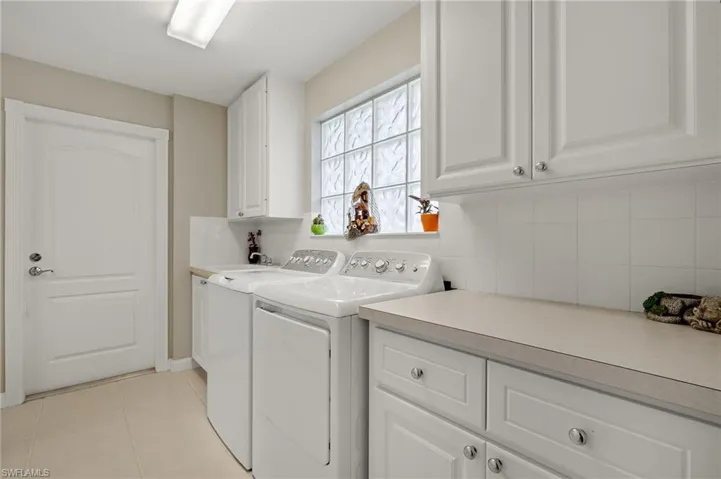 Laundry area featuring cabinets, independent washer and dryer, and light tile patterned flooring