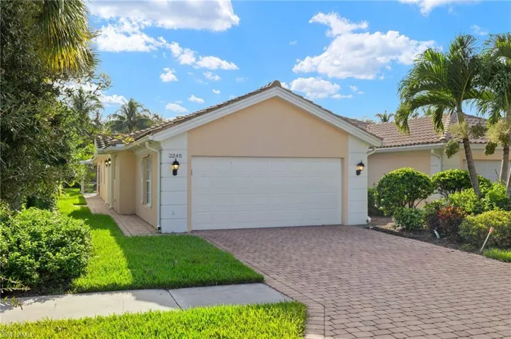 Single story home featuring a garage and a front lawn