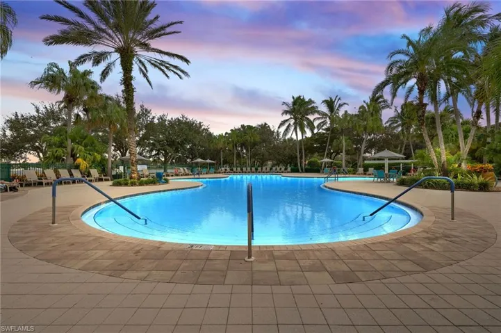 Pool at dusk featuring a patio area