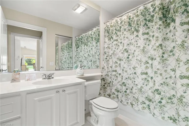 Full bathroom featuring vanity, shower / bath combo with shower curtain, and toilet