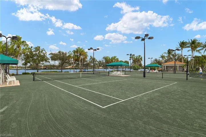View of tennis court featuring a water view