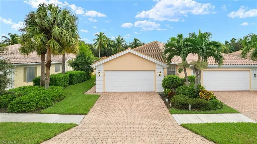 View of front of property with a garage and a front lawn