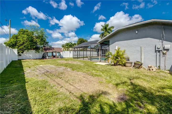 Fenced backyard featuring a sunroom and glass enclosure