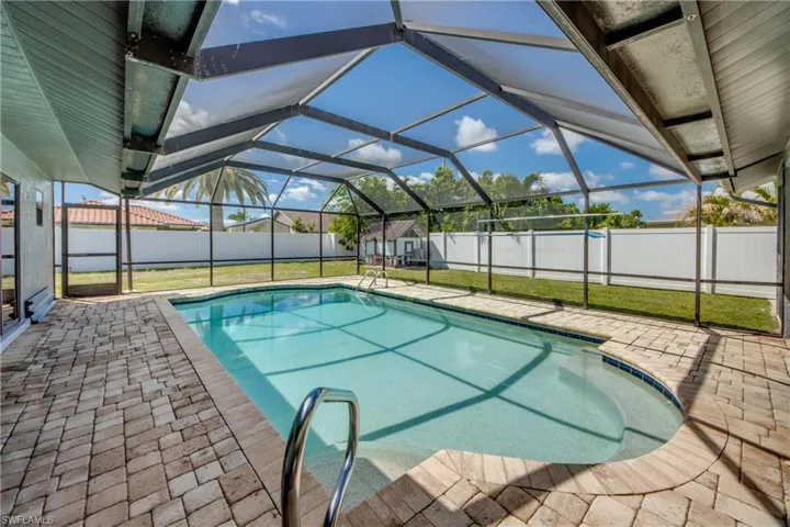 View of swimming pool featuring glass enclosure, a patio, a sunroom, and a fenced backyard
