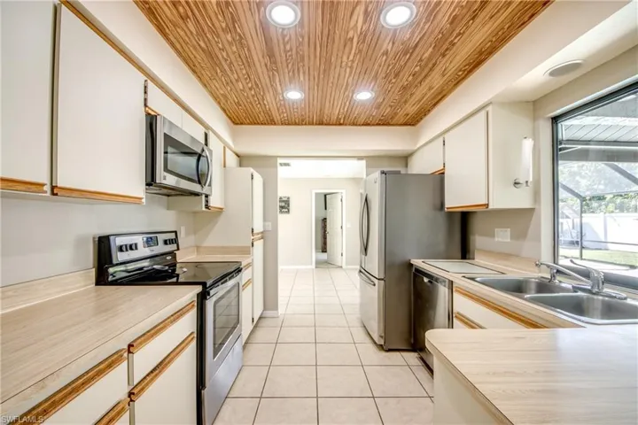 Kitchen featuring appliances with stainless steel finishes, light countertops, recessed lighting, wood ceiling, and white cabinetry