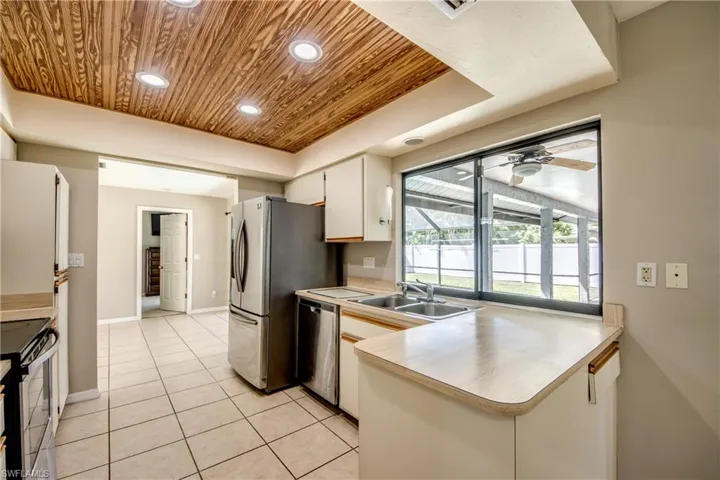 Kitchen with light countertops, wooden ceiling, recessed lighting, appliances with stainless steel finishes, and light tile patterned floors