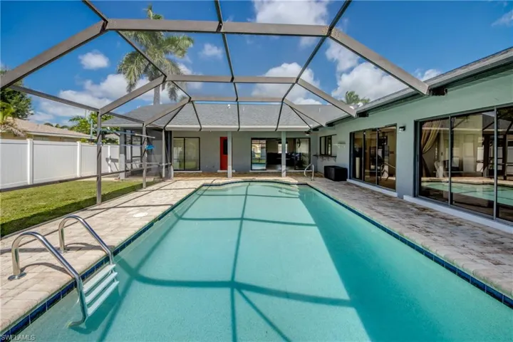 Swimming pool featuring a lanai, a sunroom, and a patio