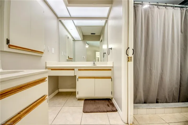 Bathroom featuring vanity, light tile patterned flooring, and a shower with shower curtain