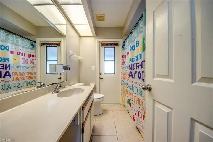Full bath with vanity, light tile patterned flooring, and a shower with shower curtain