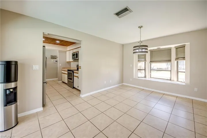 Unfurnished dining area featuring light tile patterned flooring and a chandelier