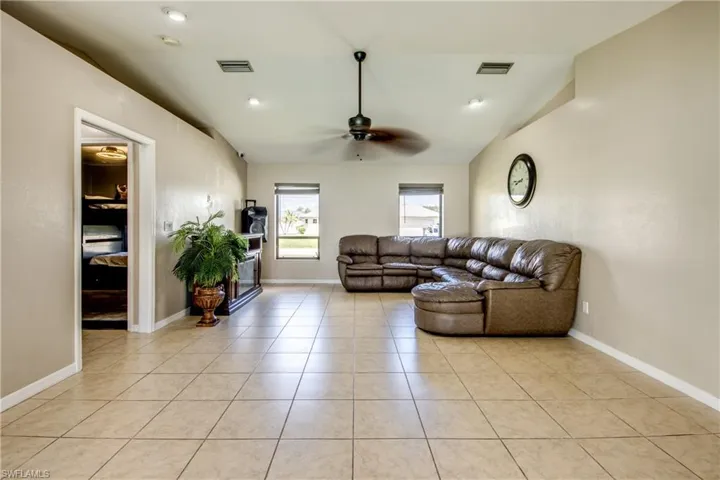 Living room featuring light tile patterned floors, a ceiling fan, and recessed lighting