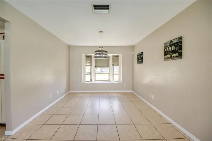 Unfurnished dining area with light tile patterned floors and a chandelier