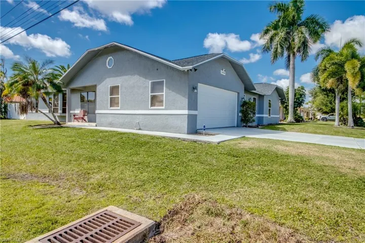 Ranch-style home featuring stucco siding, a front yard, concrete driveway, and an attached garage
