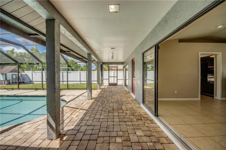 Unfurnished sunroom featuring a patio and a pool