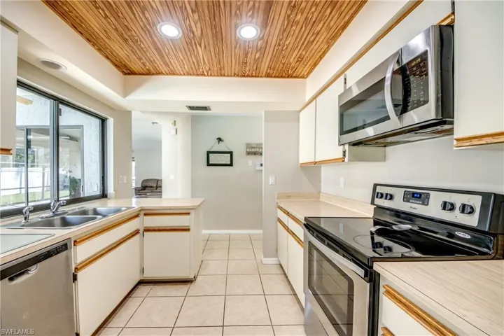 Kitchen featuring appliances with stainless steel finishes, recessed lighting, wooden ceiling, light countertops, and a peninsula