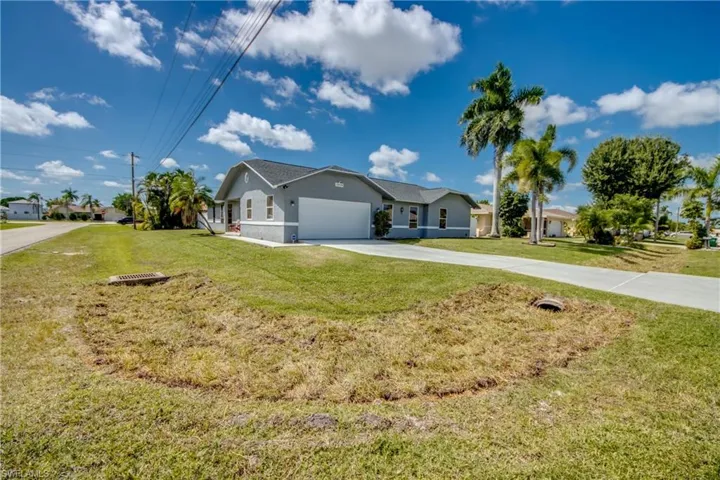 Single story home with concrete driveway, stucco siding, a front lawn, and a garage