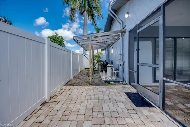 Fenced backyard with a patio area and a sunroom
