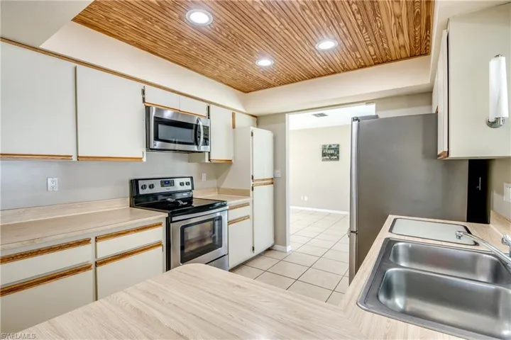 Kitchen with white cabinets, recessed lighting, light countertops, stainless steel appliances, and light tile patterned floors