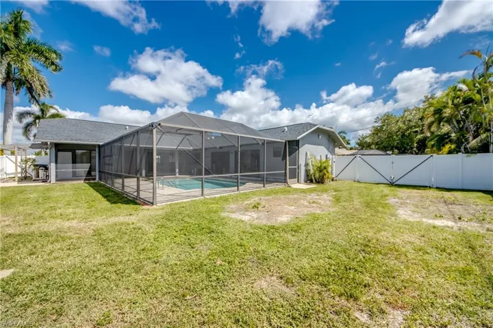 Fenced backyard with a gate, a lanai, a sunroom, and a patio