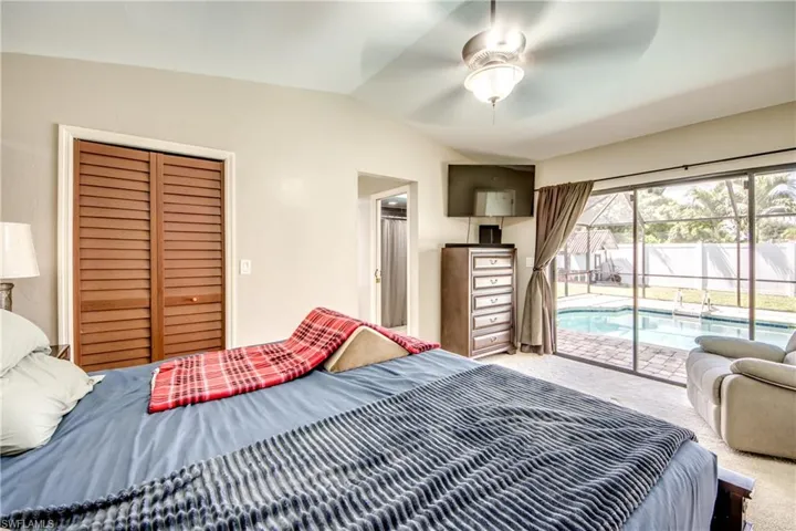 Bedroom with access to outside, carpet floors, vaulted ceiling, a ceiling fan, and a closet