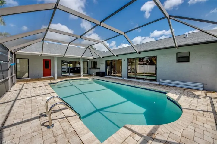 Swimming pool with a lanai, a sunroom, and a patio area
