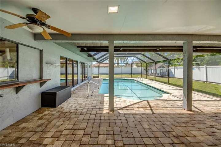 View of swimming pool featuring a patio area, a sunroom, a fenced backyard, a lanai, and a ceiling fan