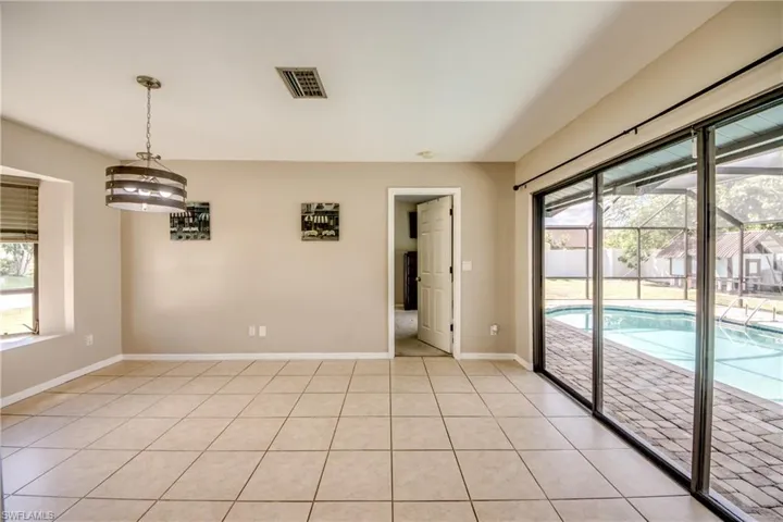 Empty room featuring light tile patterned floors and a sunroom