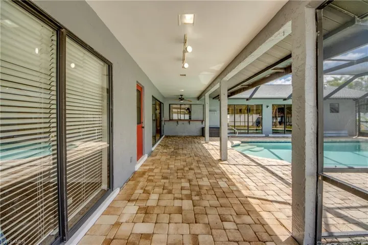 Swimming pool featuring a patio area, a lanai, a ceiling fan, and a sunroom