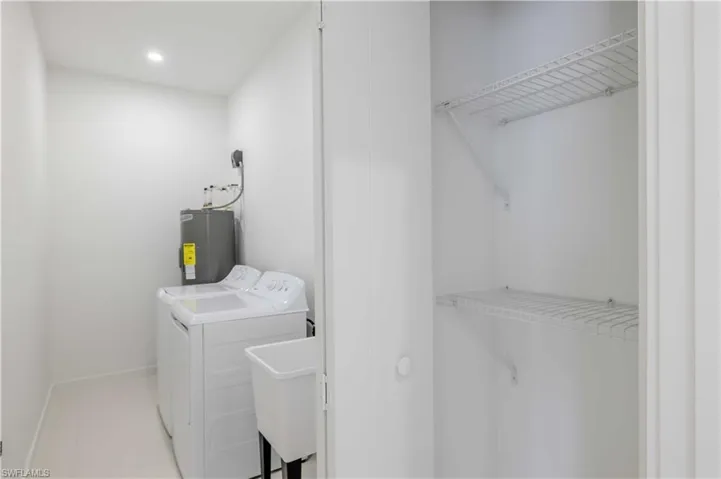Laundry area with electric water heater and separate washer and dryer