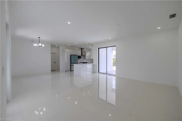 Unfurnished living room with a chandelier and light tile patterned flooring
