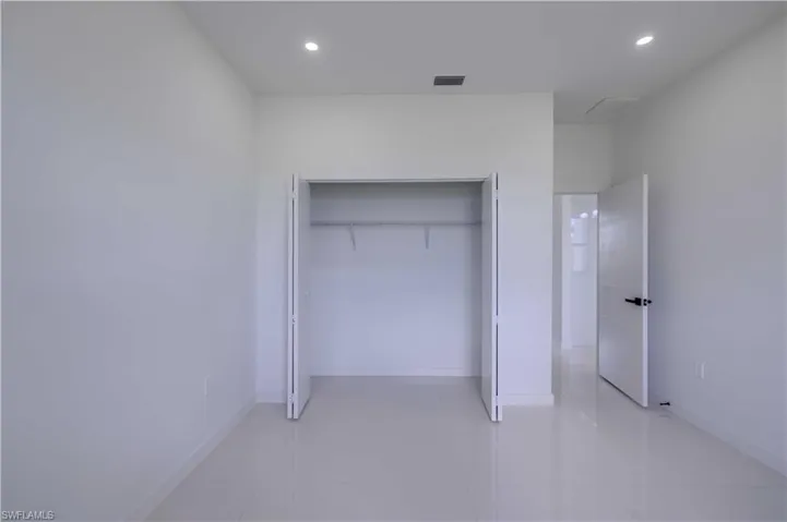 Unfurnished bedroom with recessed lighting, light tile patterned floors, and a closet