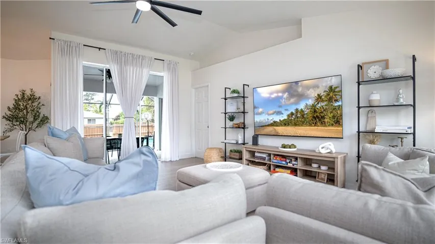 Living area featuring wood finished floors, ceiling fan, and lofted ceiling