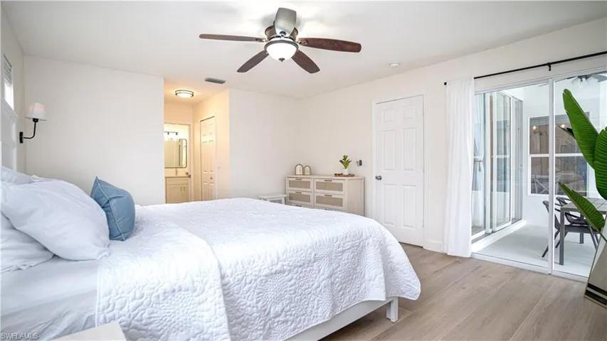 Bedroom with light wood finished floors, access to outside, a ceiling fan, ensuite bath, and a closet