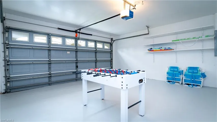 Recreation room featuring a garage and finished concrete flooring