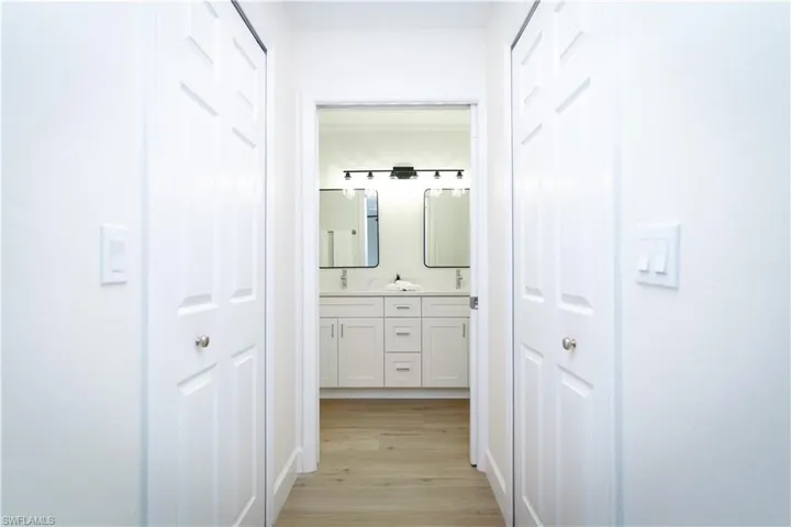 Corridor with light wood finished floors and a sink