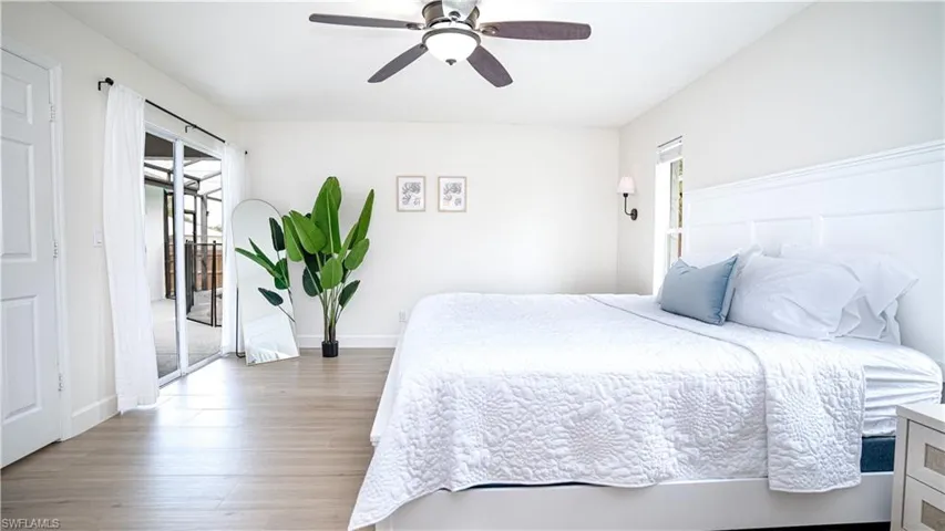 Bedroom with a ceiling fan, wood finished floors, and access to outside