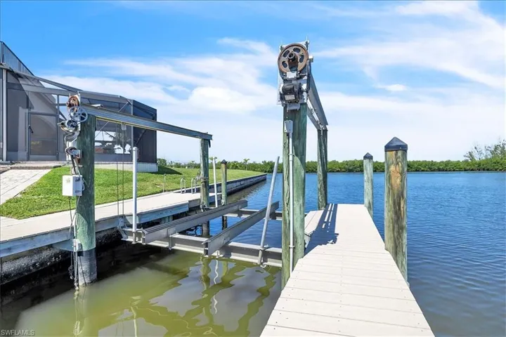 Waterfront property featuring a private boat lift, a composite dock, and direct canal access