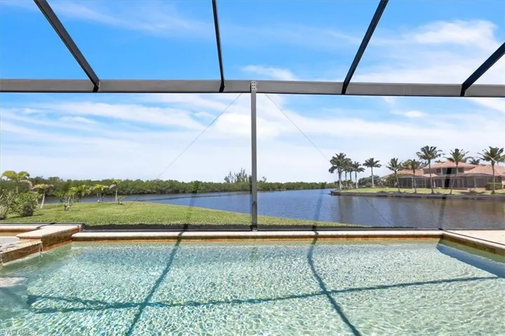 Screened lanai featuring a clear water pool, integrated spa, and tiled surround